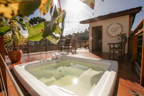 a large bath tub on a patio with a house at Pousada das Hortênsias in Campos do Jordão