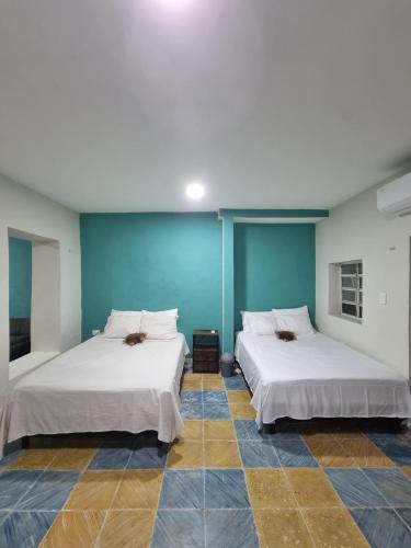 two beds in a room with blue walls at Merida Centro House with Private Pool and Air Conditioning in Mérida