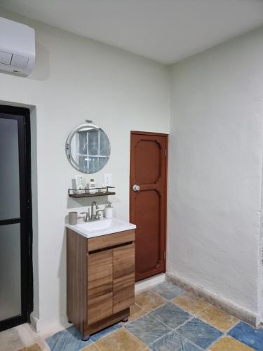 a bathroom with a sink and a brown door at Merida Centro House with Private Pool and Air Conditioning in Mérida