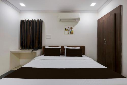 a bedroom with a large bed with black and white sheets at Hotel CJ Grand Vijayawada in Vijayawāda