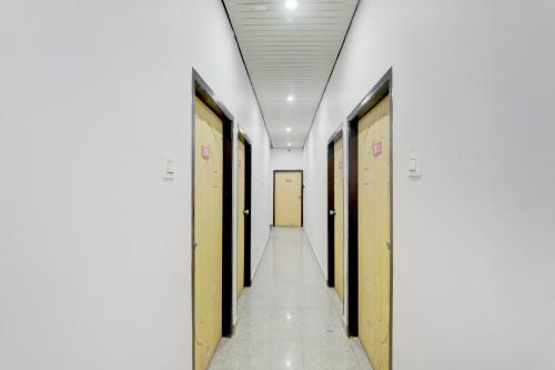 a corridor of a hospital hallway with yellow doors at Hotel O Shri Buddheshwar Temple Lucknow in Alambagh