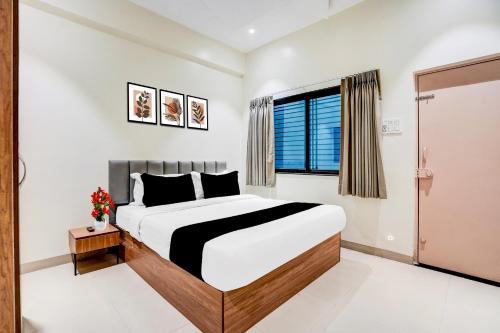 a bedroom with a large bed and a window at Collection O Shendra MIDC Aurangabad Formerly Sai Palace in Aurangabad