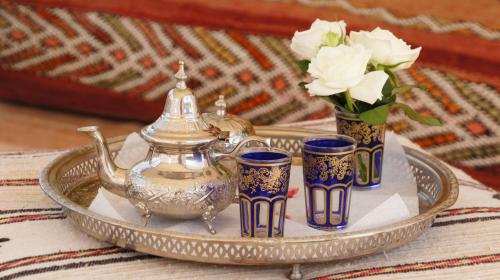 a silver tray with a tea pot and three cups at Riad Jardin des Orangers in Taroudant