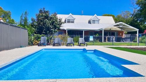 a swimming pool in front of a house at Sandy Feet Retreat in Geographe