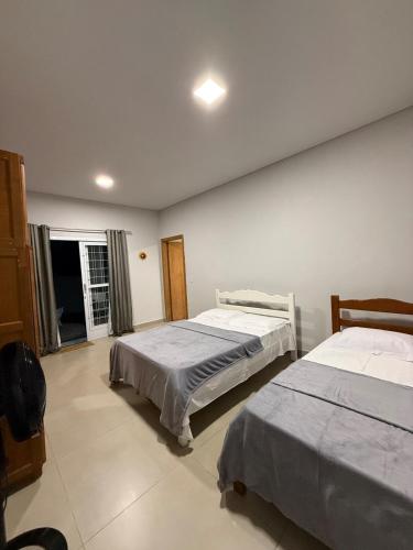 a bedroom with two beds and a window at Casa 3 Suites Confortaveis in Chapada dos Guimarães