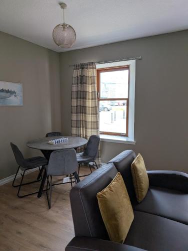 a living room with a couch and a table and a window at Argyll Place in Campbeltown