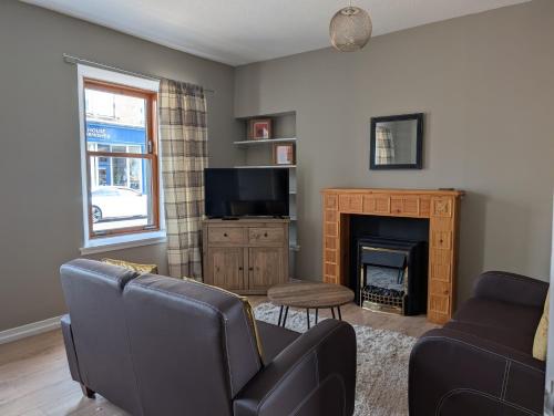 a living room with a couch and a fireplace at Argyll Place in Campbeltown