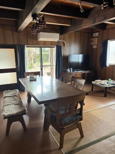 a dining room with a large wooden table and chairs at Edo house in Shiigi