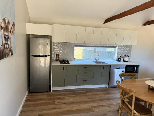 a kitchen with a stainless steel refrigerator and a table at The Grain Shed in Euroa