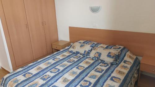 a bedroom with a bed with a blue comforter at Panoramic 3-Bedroom Chalet with Terrace-Garden in Kfardebian