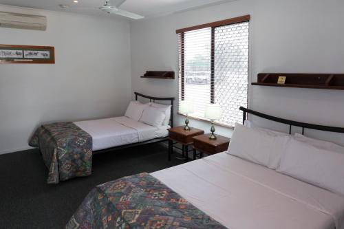a hotel room with two beds and a window at The Moonie Crossroads Hotel in Moonie