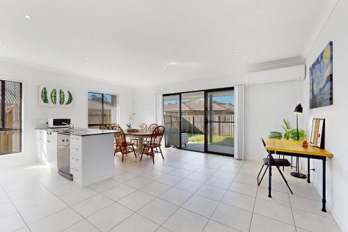 a kitchen and dining room with a table and chairs at 4BR Family Home Coomera Theme Parks Shopping in Gold Coast