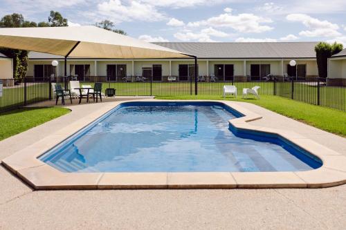 a swimming pool in a yard with a table and chairs at Roma Explorers Inn in Roma