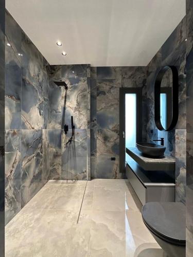 a bathroom with a sink and a toilet and a mirror at Luxury Villa in Calabria in Gasponi