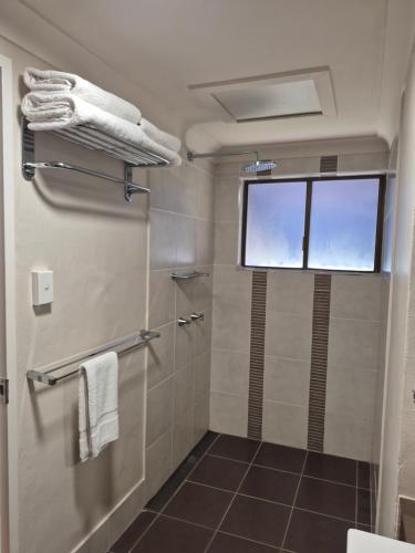 a bathroom with a shower and a window at Sovereign Resort Hotel in Cooktown