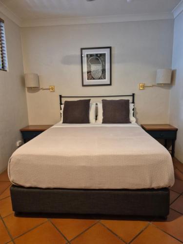 a bedroom with a large bed with two pillows at Sovereign Resort Hotel in Cooktown