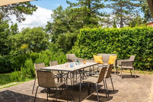 a patio with a table and chairs on a patio at Historic Farmhouse Between Two Tuscan Valleys in Trequanda