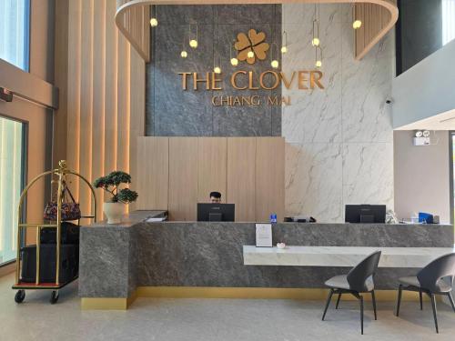a lobby with a counter and chairs and a sign at The Clover in Chiang Mai