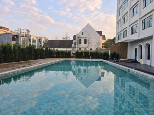 a swimming pool in front of a building at The Clover in Chiang Mai