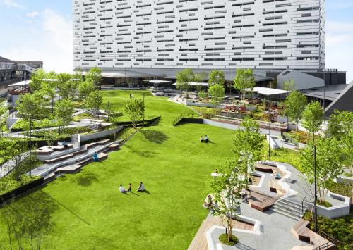 an overhead view of a park with a large building at OMO7 Osaka by Hoshino Resorts in Osaka