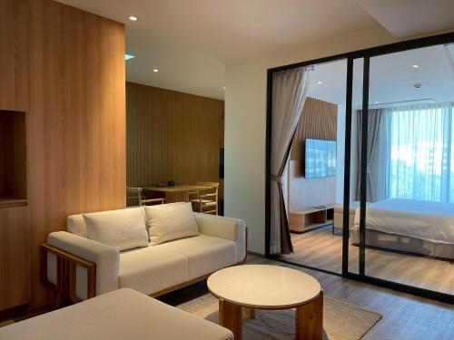 ein Wohnzimmer mit Sofa und ein Schlafzimmer in der Unterkunft The Clover in Chiang Mai