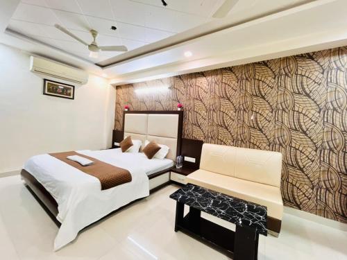 a bedroom with a bed and a couch and a wall at Lijoy Hotel & Restra in Būndi