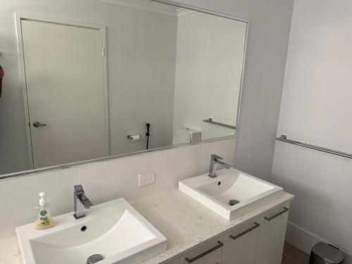 a bathroom with two sinks and a large mirror at Beach House Shared in Alkimos