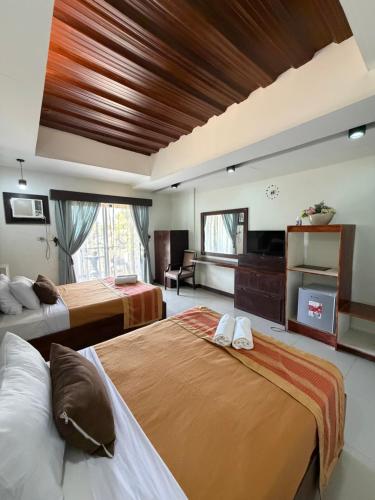 a hotel room with two beds and a television at Bantay Viajeros Inn in San Julian Norte
