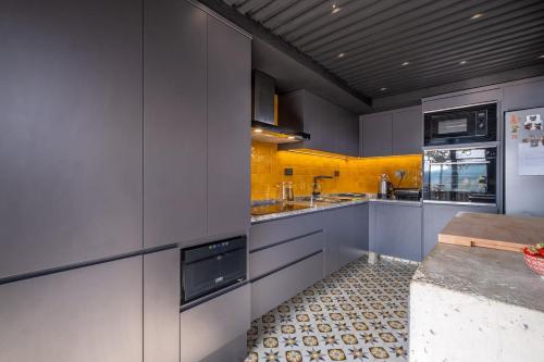 a kitchen with gray cabinets and yellow walls at Villa Baraka in İznik