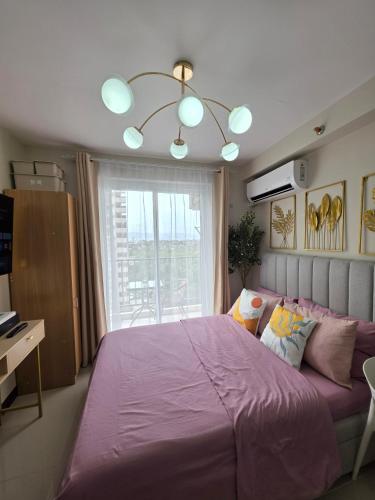 a bedroom with a large purple bed with a window at Saekyung Lapu-lapu in Suba