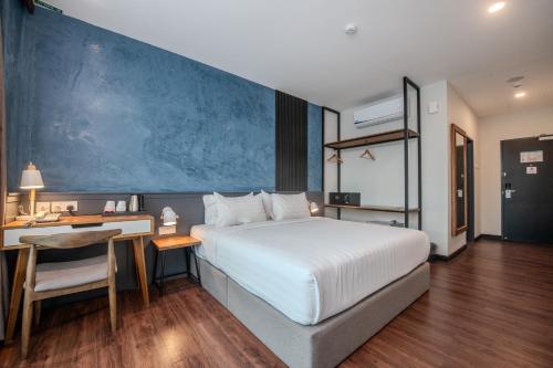 a hotel room with a bed and a desk and a desk at O&G Hotel Parit Buntar in Parit Buntar
