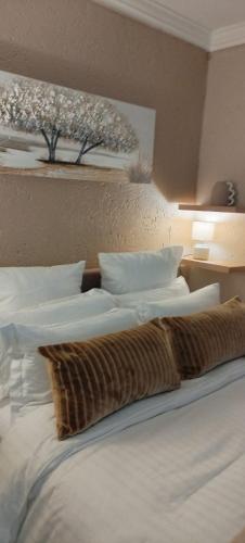 a bedroom with a bed with white sheets and pillows at Executive en-Suite - Southgate in Southgate