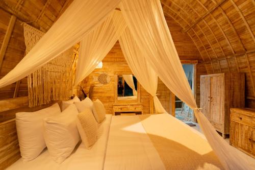 a bedroom with a bed with a canopy at Ratna's Green Hill Penida by Bali Cabin in Nusa Penida
