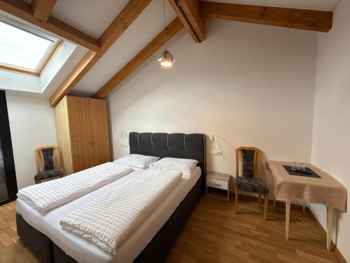 a bedroom with a bed and a table and chairs at Hohenbichl in Terento