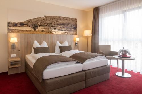 um quarto com uma cama grande num quarto em Hotel Weserschiffchen em Porta Westfalica