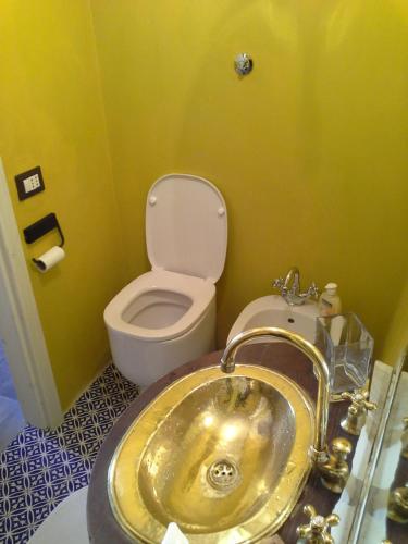 a bathroom with a gold sink and a toilet at Agave di mare in Riomaggiore