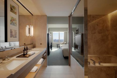 a bathroom with two sinks and a bedroom at Park Hyatt Tokyo in Tokyo