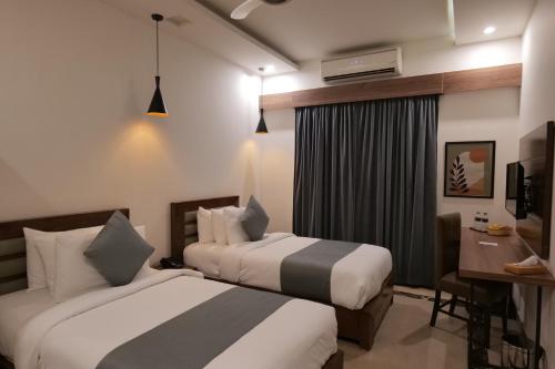 a hotel room with two beds and a desk at Xefan Hotels in Karachi