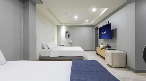 a hotel room with two beds and a bathroom at 호텔 페르소나 in P'ungnyŏn-gol