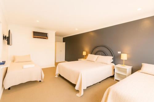 a hotel room with two beds and two tables at MOTEL ROYAL TARA in Binalong