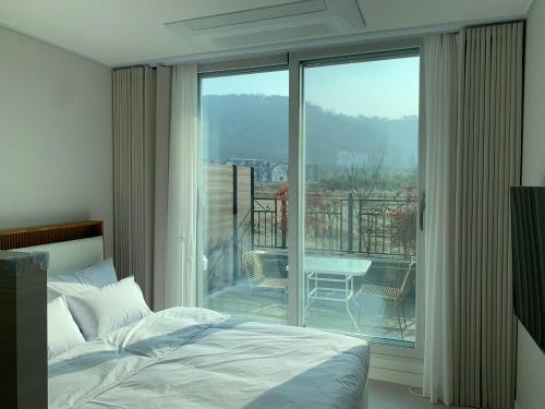 a bedroom with a bed and a view of a balcony at Two Rest Pension in Damyang