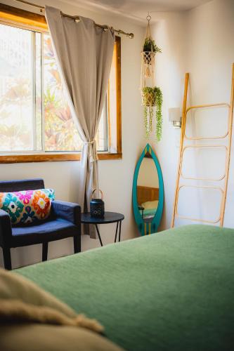 a bedroom with a bed and a mirror and a chair at Surf Shack in Iconic Rainbow Bay - Coolangatta QLD (pet friendly) in Gold Coast