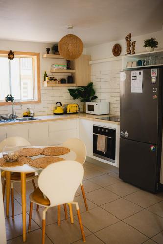 a kitchen with a black refrigerator and a table and chairs at Surf Shack in Iconic Rainbow Bay - Coolangatta QLD (pet friendly) in Gold Coast