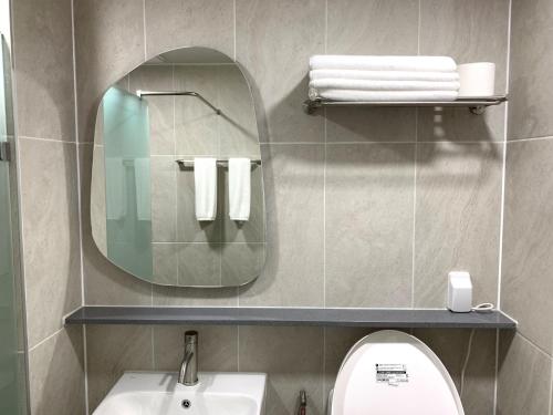 a bathroom with a mirror and a sink and a toilet at Two Rest Pension in Damyang