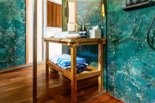 a bathroom with a table with a sink and a mirror at Kama Haven in Semaya