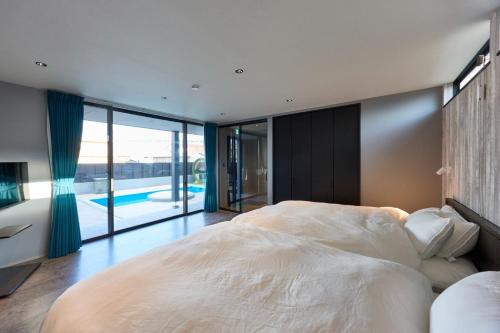 a bedroom with a large bed and a swimming pool at Ocean Bridge - Vacation STAY 76453v in Awaji