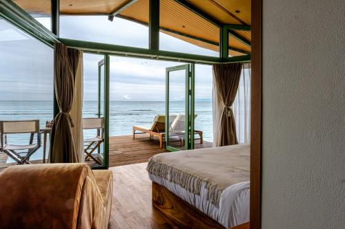 a bedroom with a bed and a view of the ocean at Kama Haven in Semaya