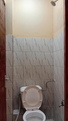 a bathroom with a toilet with a light above it at Breezes home Bamburi in Bamburi