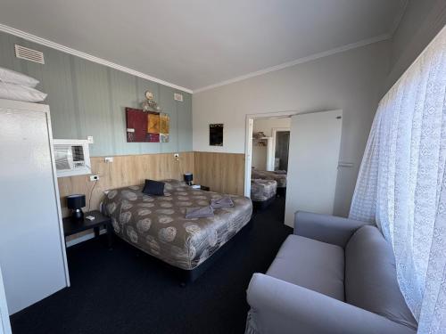 a hotel room with a bed and a couch at Blue Lake Motel in Mount Gambier