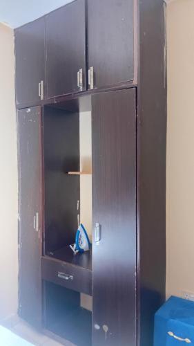 a brown cabinet with its door open in a room at Breezes home Bamburi in Bamburi
